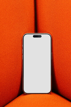 Smartphone Mockup with White Screen on Red Sofa