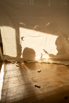 Children&rsquo;s Shadow Play Behind Curtain in Sunlight
