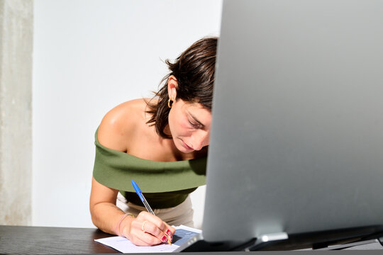 writing notes on a resume while her work day