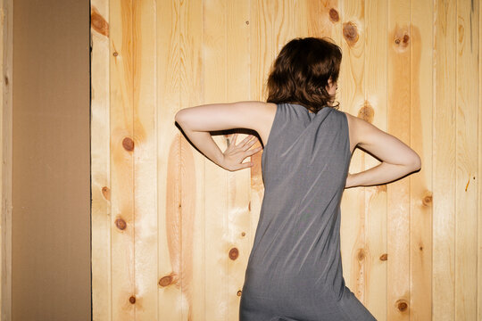 Anonymous woman leaning against wall