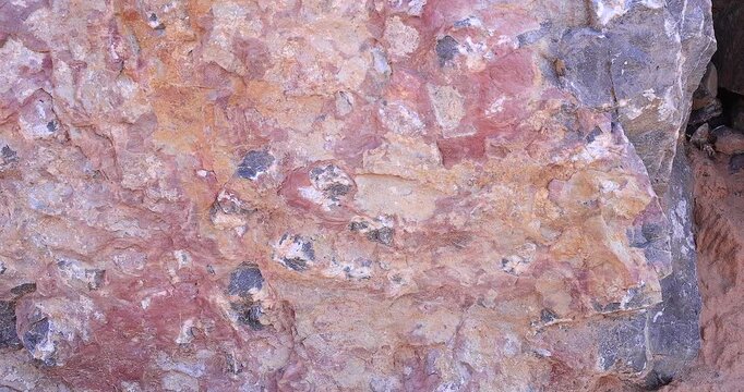 Closeup panoramic of many multi color rock surface with extensive abstract pattern of mineral stones embedded in face 4k