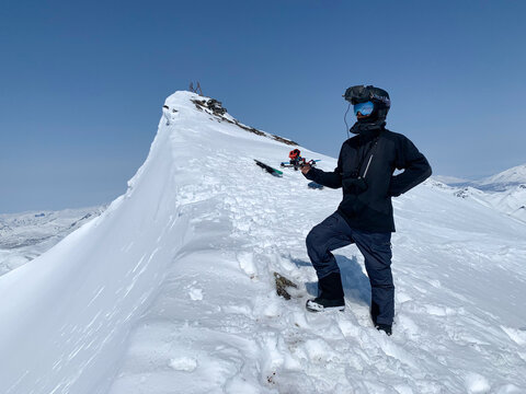 Man with FPV drone standing on alpine ridge