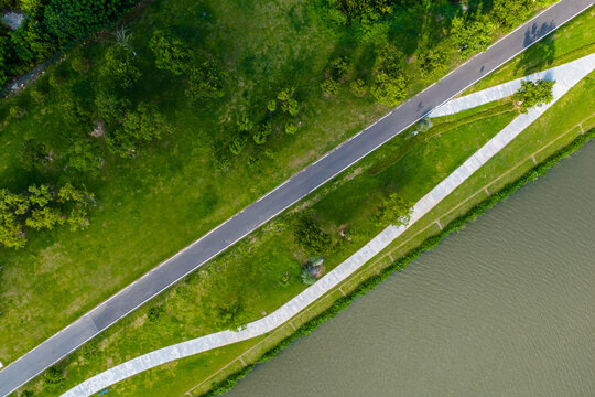 Top View of Green Park with Curved Walkway and Riverbank