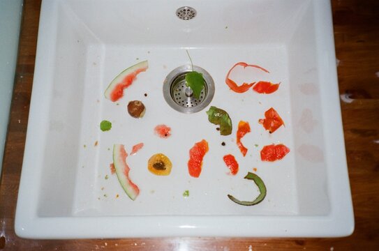 Fresh fruit scraps and vegetable peels collected in a kitchen sink 