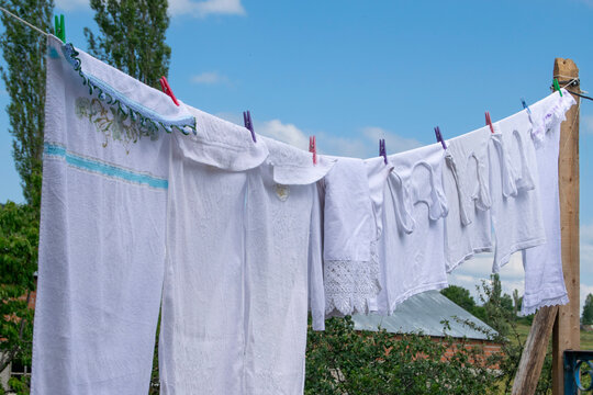 Freshly Laundered White Fabric Hanging to Dry Outdoors on a Sunny Day