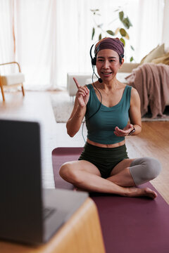 Woman leads online yoga class from home.