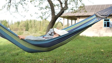 Child relaxing in hammock on summer day