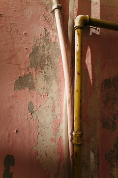Rusty Pipes Vs. Peeling Pink Wall