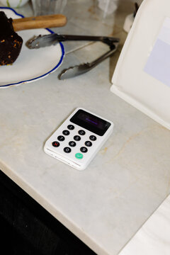 A portable credit card payment terminal placed on the counter