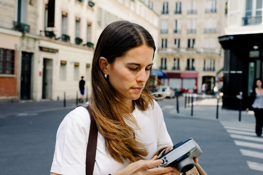 Female tourist using a retro camera to take photos in Paris