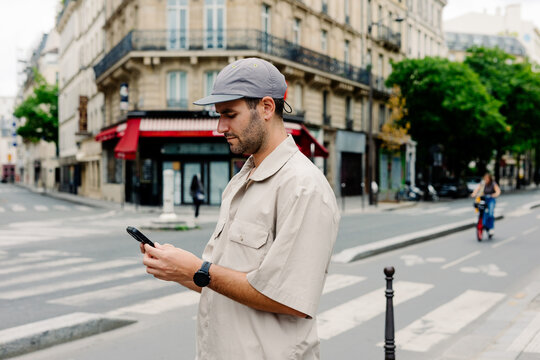 Visitor typing on his smartphone while walking through central Paris