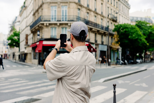 Traveler capturing photos with a mobile device in central Paris