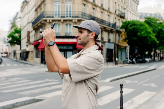 Tourist using his phone to take photos in the streets of central Paris