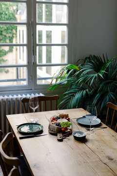 An indoor table with raw salmon and French cheese