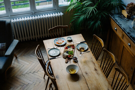 Overhead angle showing a tabletop with wine cups and sliced cheese
