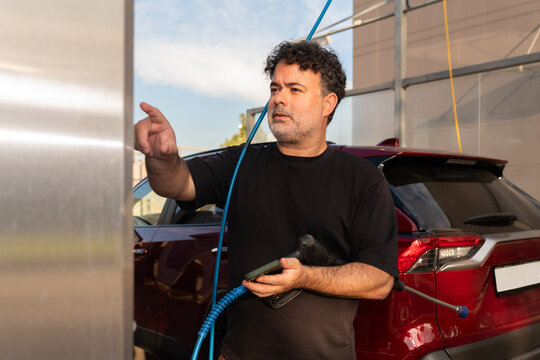 Man Ordering Cleaning Program at Self-Service Wash Station