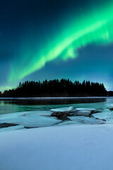 Northern lights over the Gäddviksundet in Luleå, Sweden. The water is open this winter night and on the shore lies white snow and ice floes © Thomas