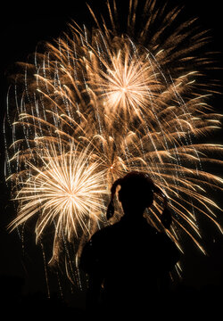 A girl's silhouette against 4th of July fireworks
