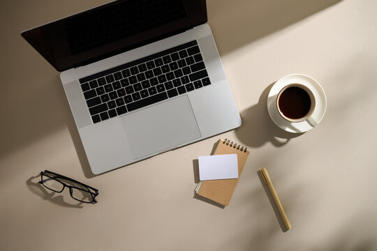 A minimalist workspace featuring a laptop, coffee, and essential items