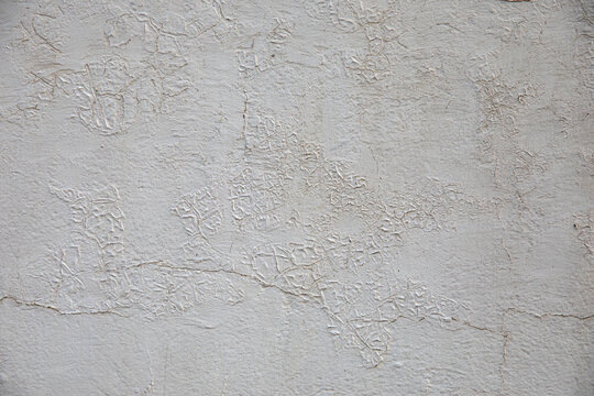 Weathered white painted wall texture with visible cracks and aging