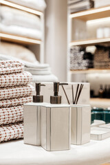Elegant bathroom accessories displayed on a countertop, featuring stylish soap dispensers and decorative towels, creating a serene and organized atmosphere for relaxation and self-care