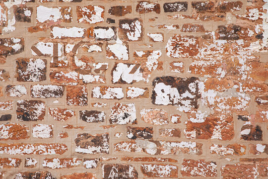 Close-up shot of a weathered brick wall, showing texture details 