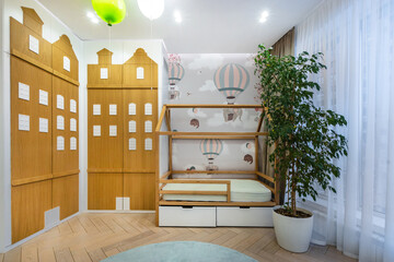 A cozy children's bedroom with unique wooden furniture and playful balloon decorations.