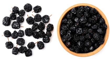 Dried Black Plums in Wooden Bowl, Top View, Isolated on White Background