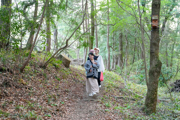 Obraz premium A woman is walking with two other women in a forest. The women are wearing black and white clothing