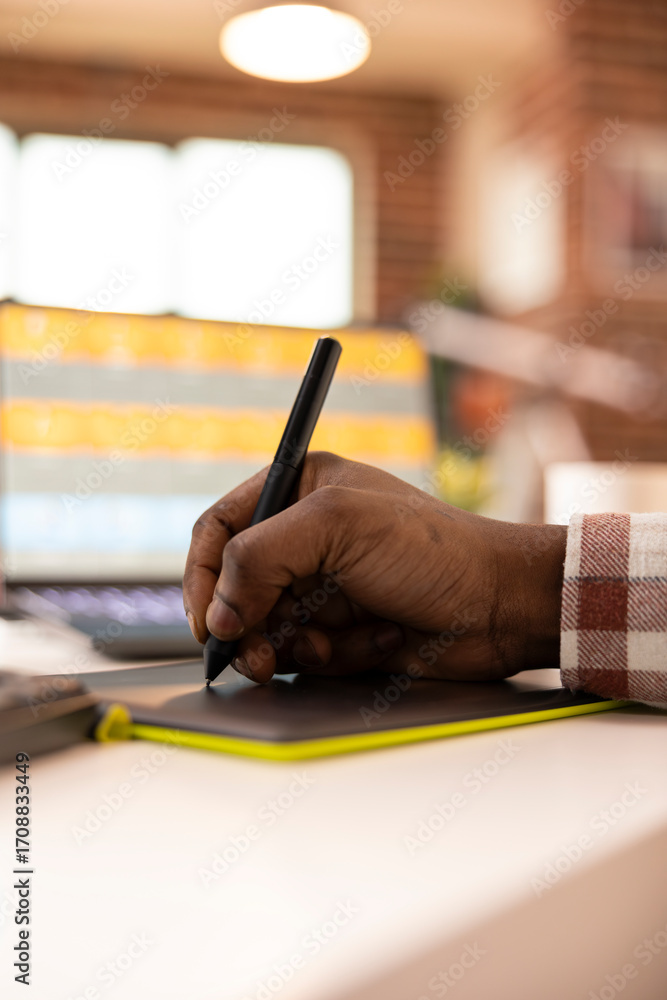 Aufkleber close up of african american hand using stylus and graphic tablet to retouch images on laptop. black
