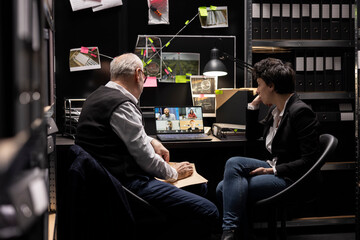 Private detectives discussing clues with remote team on video conference in an incident room, analyzing case files and surveillance photos to trace some connections. Confidential information.
