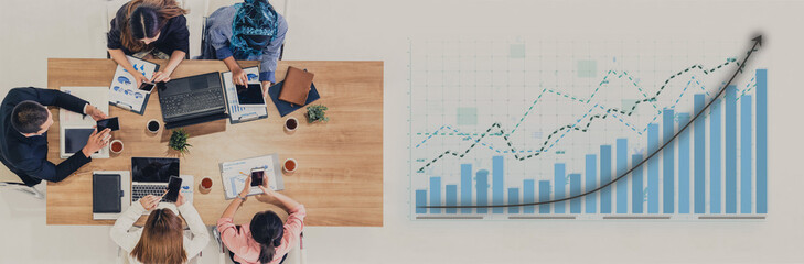 A diverse business team collaborates on financial data analysis in a modern office. They engage with charts and laptops, focusing on growth strategies. Impute