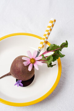 beetroot decorated with fresh flowers on a plate.