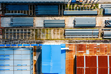 Aerial View of Industrial Yard with Stacked Piles and Warehouse Roofs