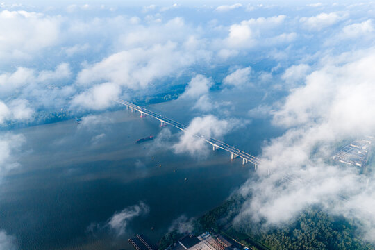 Aerial View of Bridge Across River Shrouded in Clouds