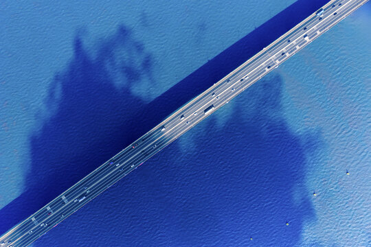 Aerial Top-Down View of Bridge Traffic Over Blue Water