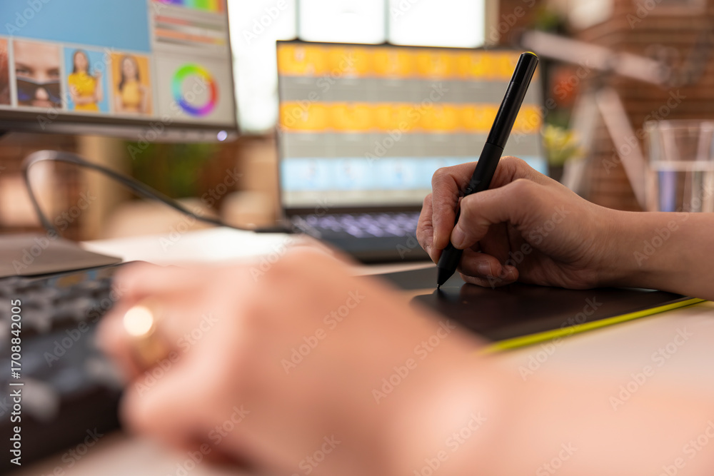 Poster closeup of hands working with stylus pen and drawing pad, enhancing photo content on desktop monitor