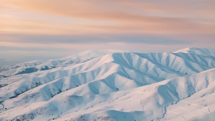 Snow-covered mountain ridges at sunset, tranquil winter landscape in pastel tones with copy space