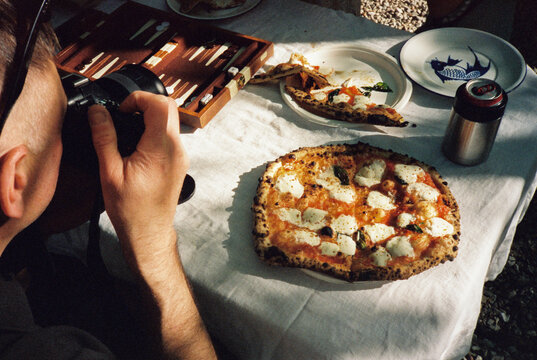 Man takes photo at pizza table