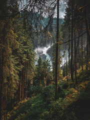 Krimml, Austria - 08-06-2025 : Wide shot of a waterfall, shot from a distance, forest in foreground