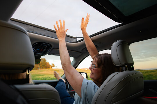 Woman Enjoying Sunroof in a Car