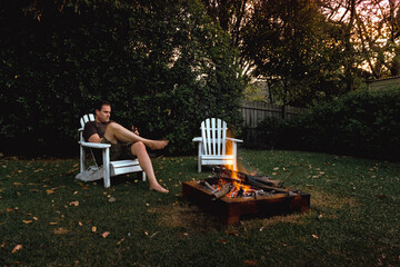 man sitting by an outdoor firepit