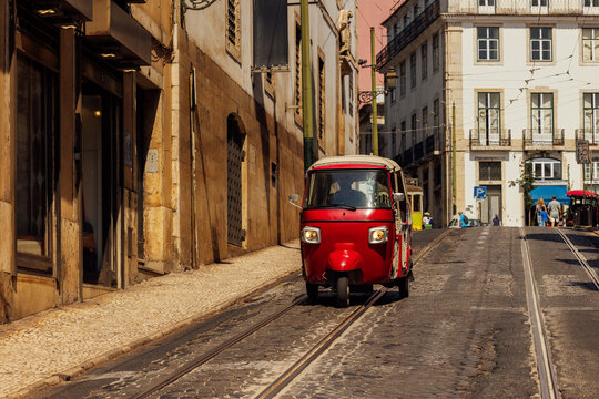 Red tuk-tuk on cobblestone streets in Lisbon's Chiado