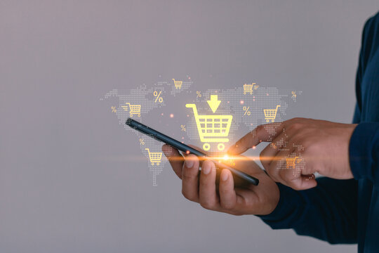 Online shopping concept with man using smartphone and digital cart icon on virtual world map, illustrating e-commerce, mobile retail, global marketplace, internet business and digital marketing.