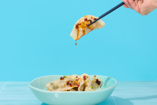 Chinese Dumplings From Bowl Dripping with Sauce 