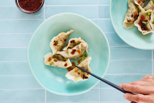 Taking a Chinese Dumplings From Bowl in Overhead View 