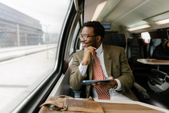Professional Man Enjoying Train Ride While Using Tablet