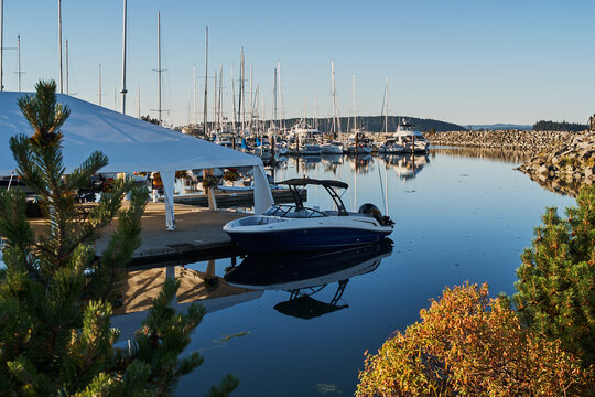 Motorboat Docked in Sidney Marina with Sailboats and Calm Reflections
