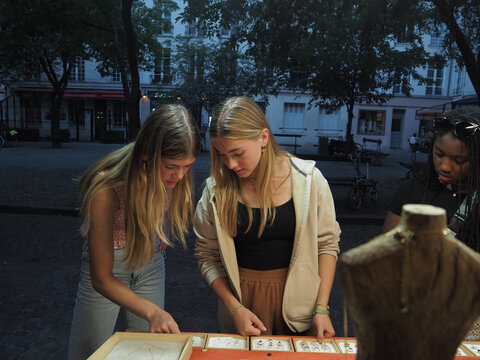 Friends Explore Unique Jewelry in Quaint Outdoor Market