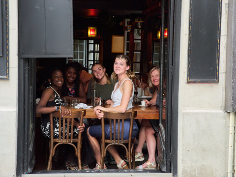 Friends Enjoying Drinks at a Cozy Cafe in Paris in the Evening